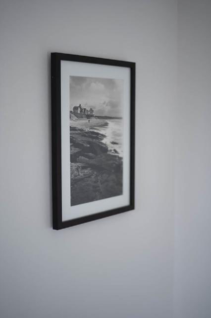 Ingelijste zwart-witfoto aan de muur van de praktijk